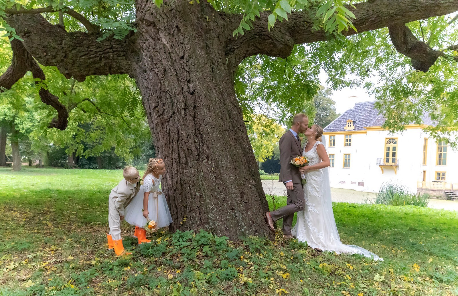 Bruin trouwpak met themakleur van de bruiloft oranje